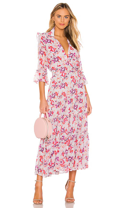 A model wearing a pink floral midi dress with three-quarter sleeves and ruffle details.